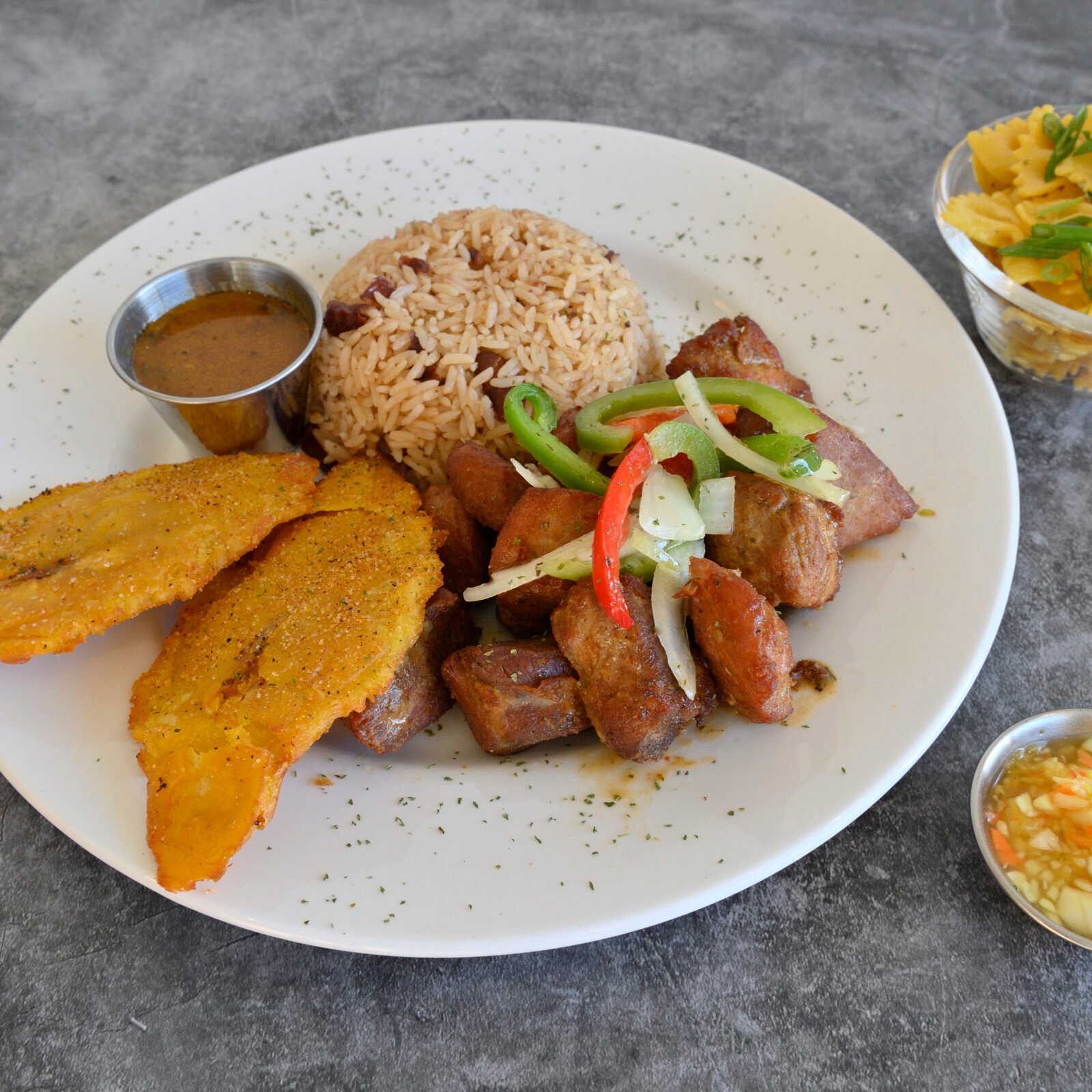 Assiette de griot avec riz, plantains et légumes marinés chez Racine Créole