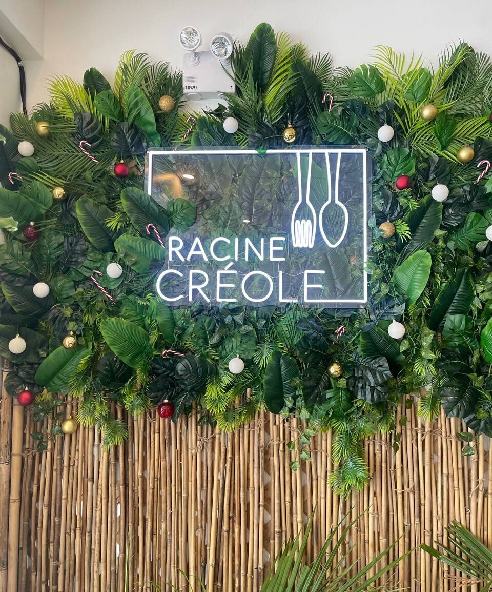 Mur végétal et enseigne lumineuse Racine Créole dans le restaurant